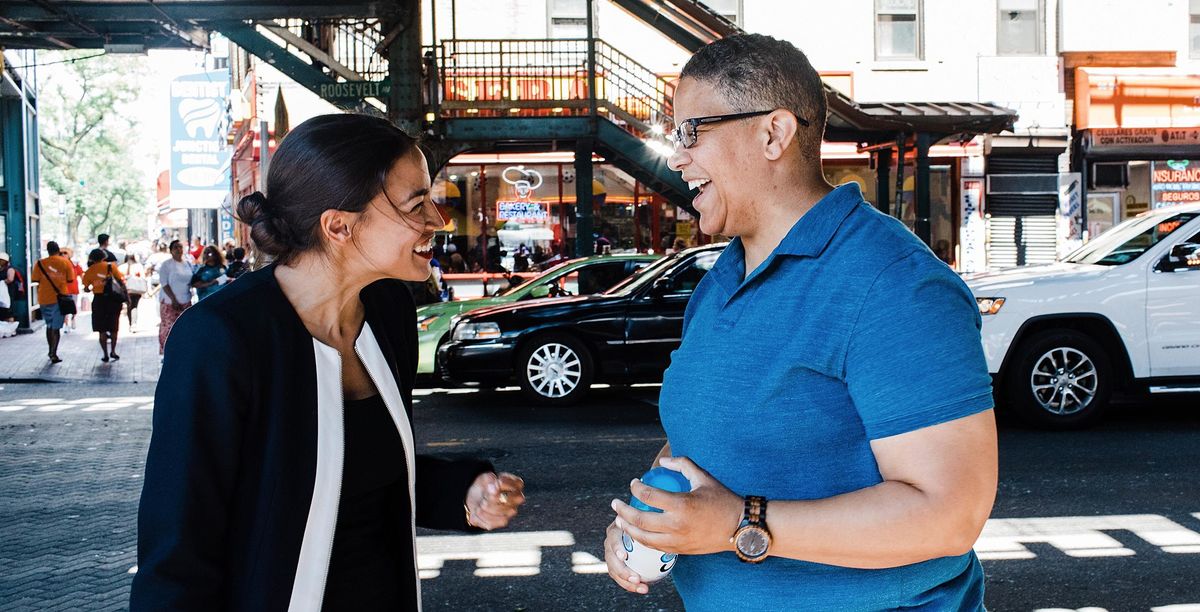 Alexandria Ocasio-Cortez and Kerri Evelyn Harris talking together outside in a street during the 2018 general election.